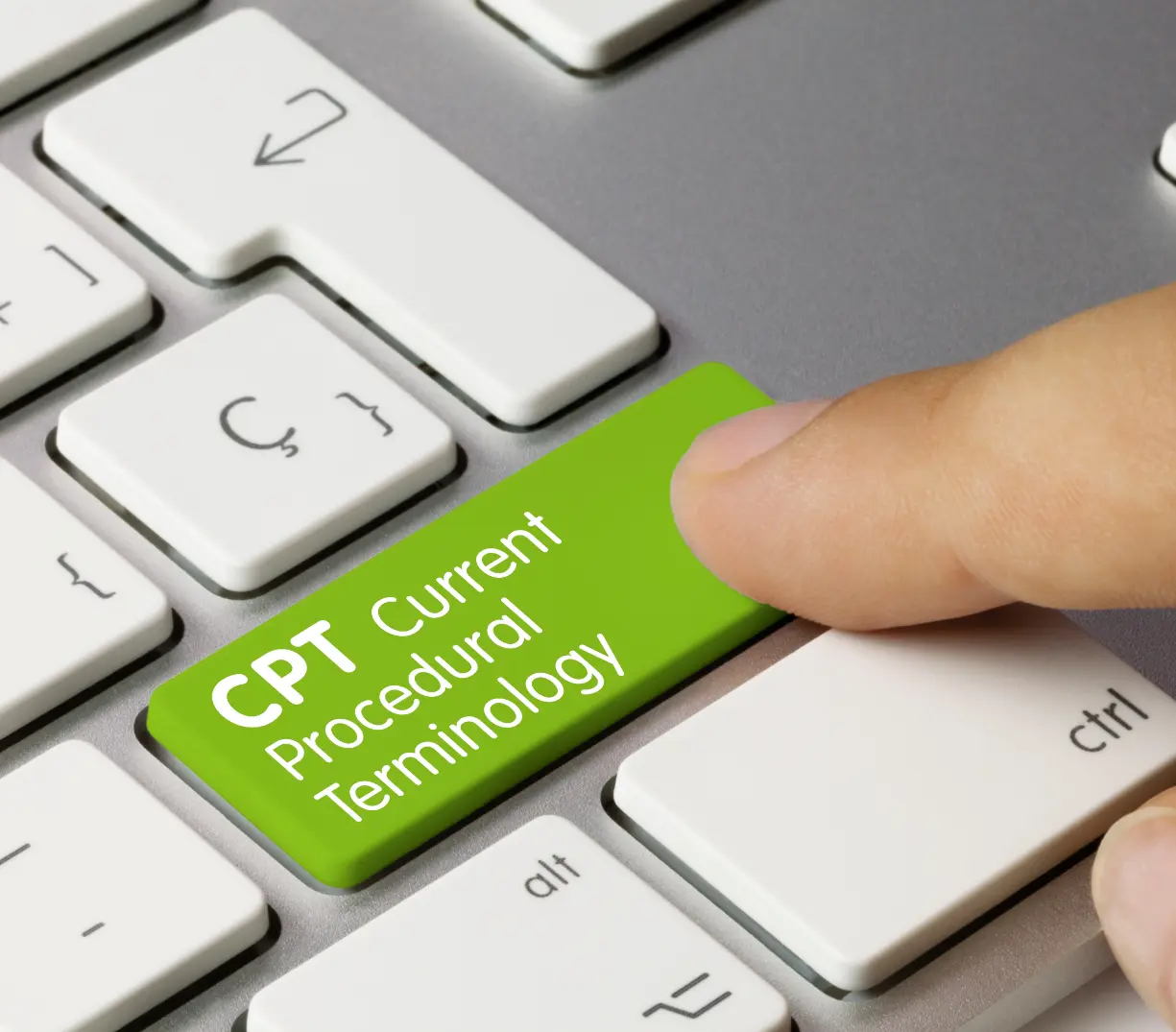 Close-up photo of a computer keyboard with a finger on a button that reads, 'CPT Current Procedural Terminology.'