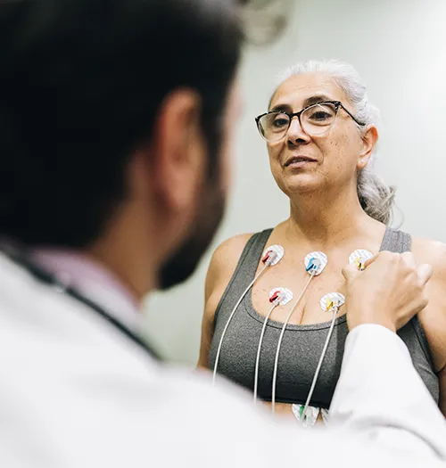 An aging woman receives a cardiac checkup to monitor coronary heart disease. 